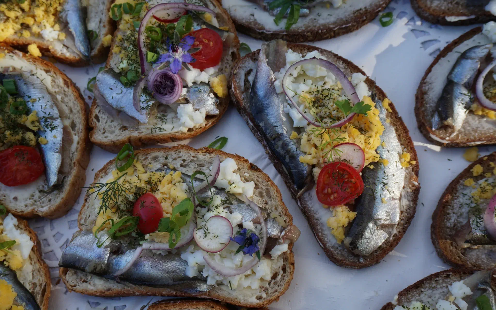 Close-up of typical dark rye bread topped with sprats and egg. This is eaten on Estonian national holidays.