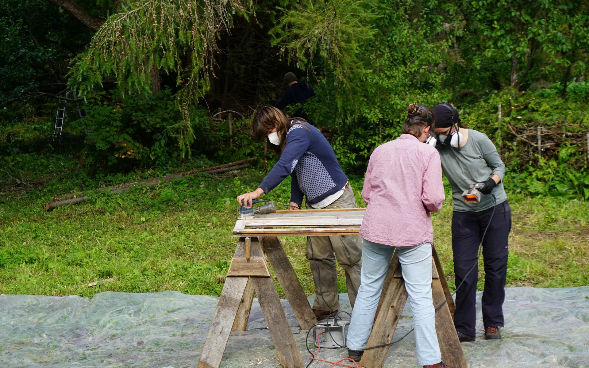 Anna, Anne, and Basti are sanding a window frame.