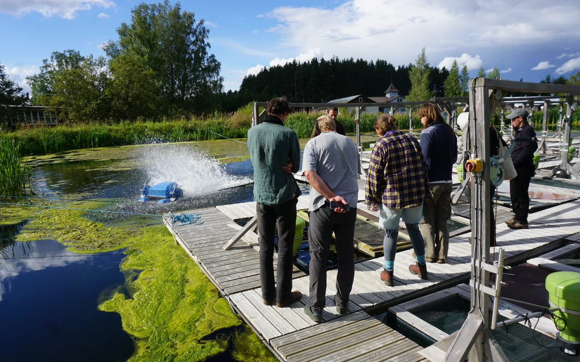 We stand on pontoons in one of the fish ponds. There, we are told something about the fish that are in the nets around us.