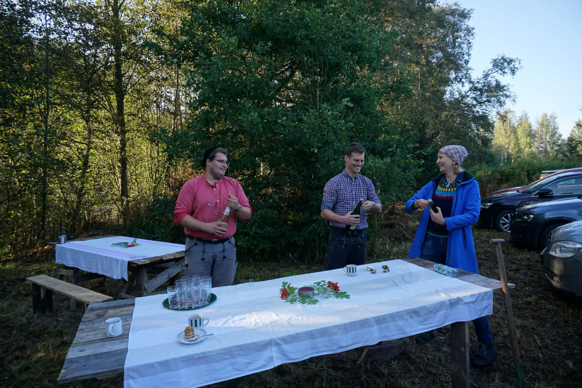 Sören, Hagen und Krista setzen zum Öffnen der Sektflaschen an