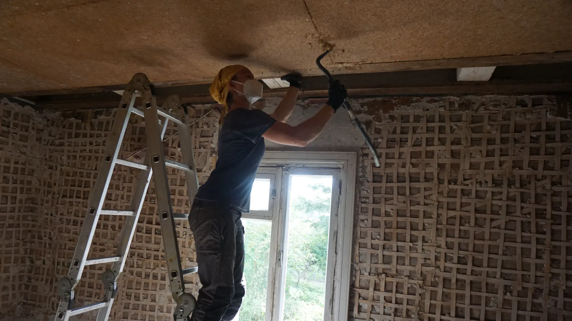 Petra works with the chisel on the ceiling panel