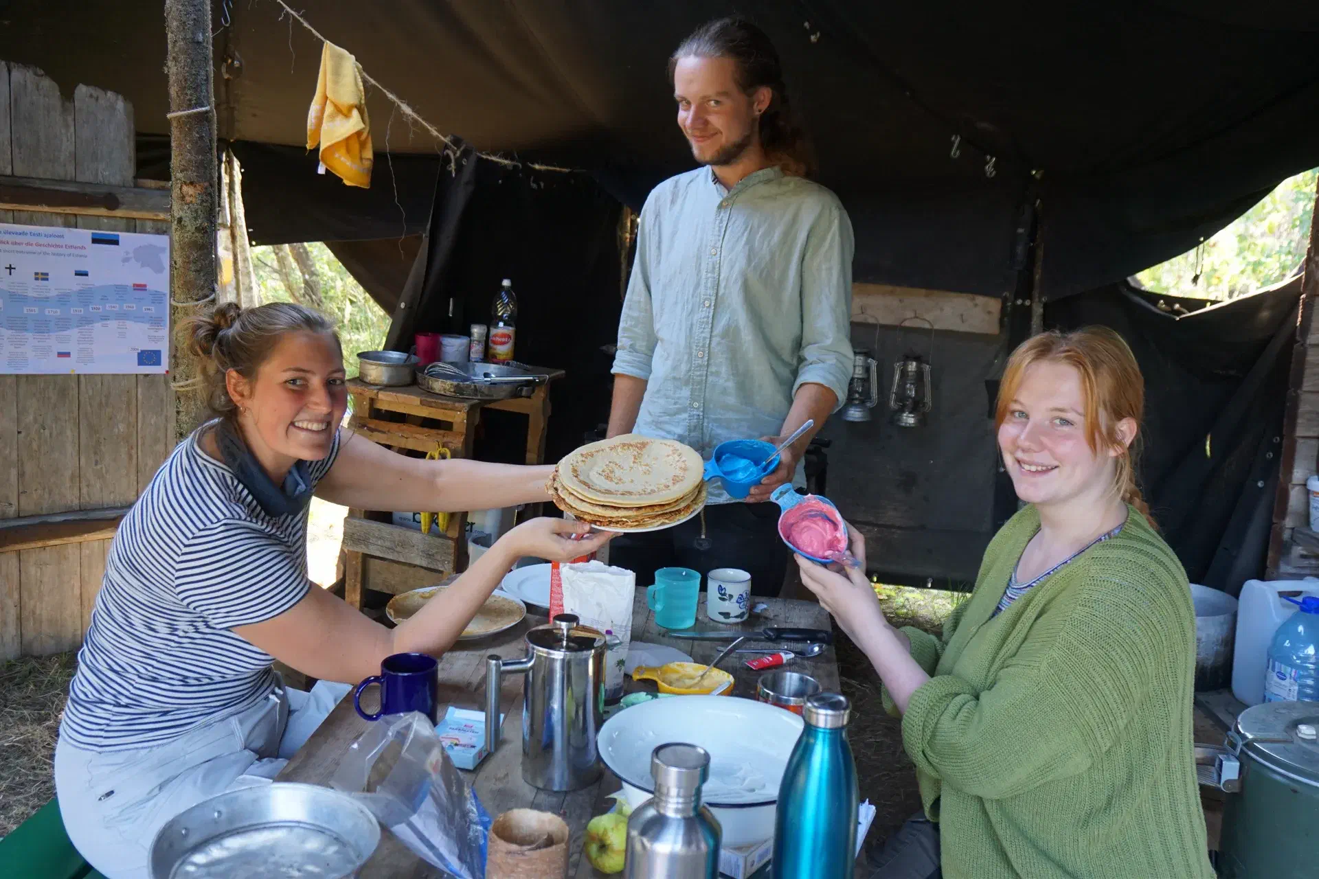 Three happy faces present a pancake-cake