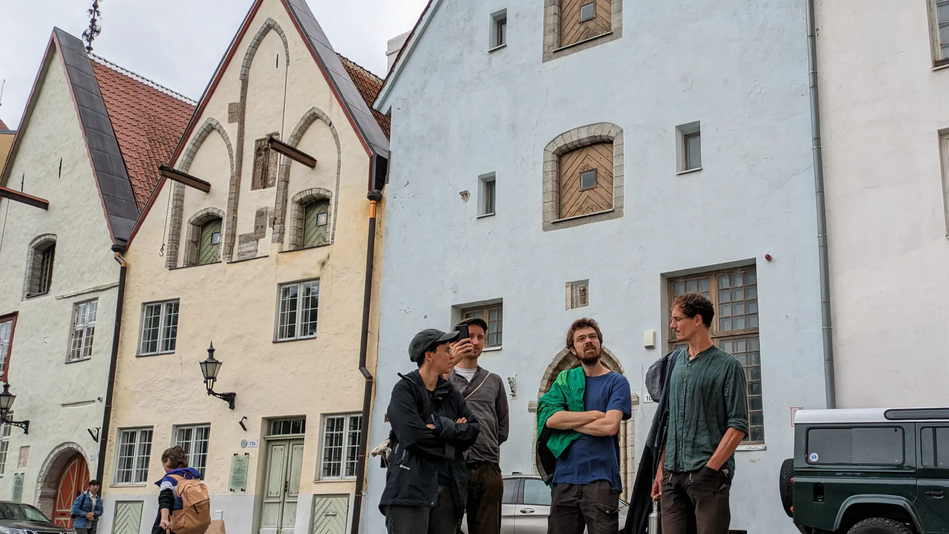 4 People stand in front of old houses