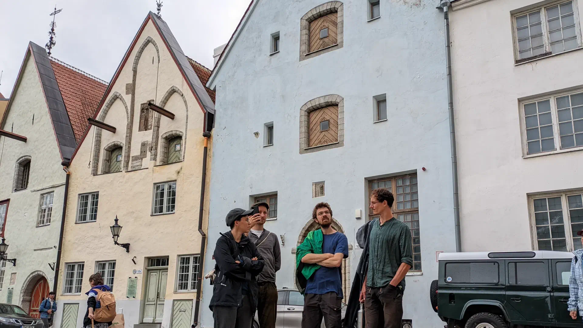 4 People stand in front of old houses