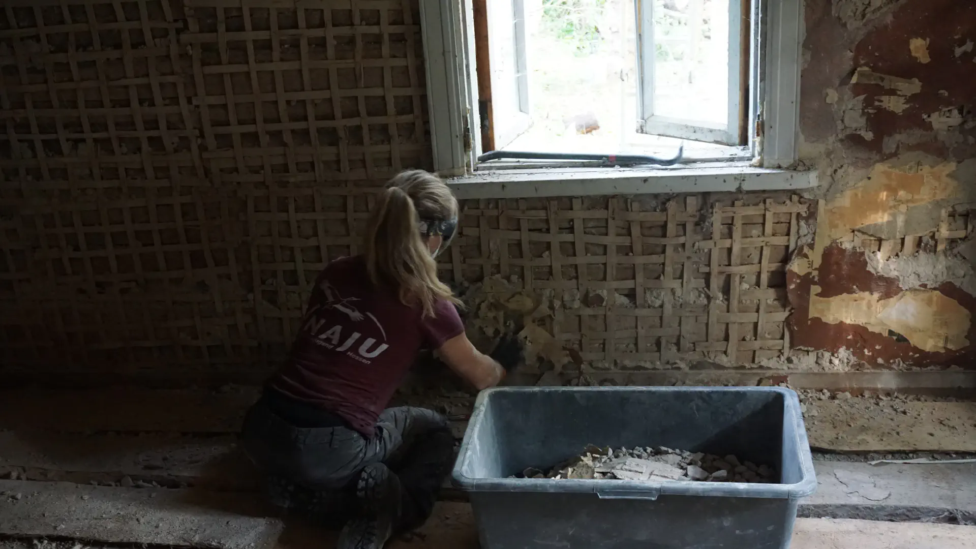 Petra knocks plaster off a wall. This reveals a fine wooden structure