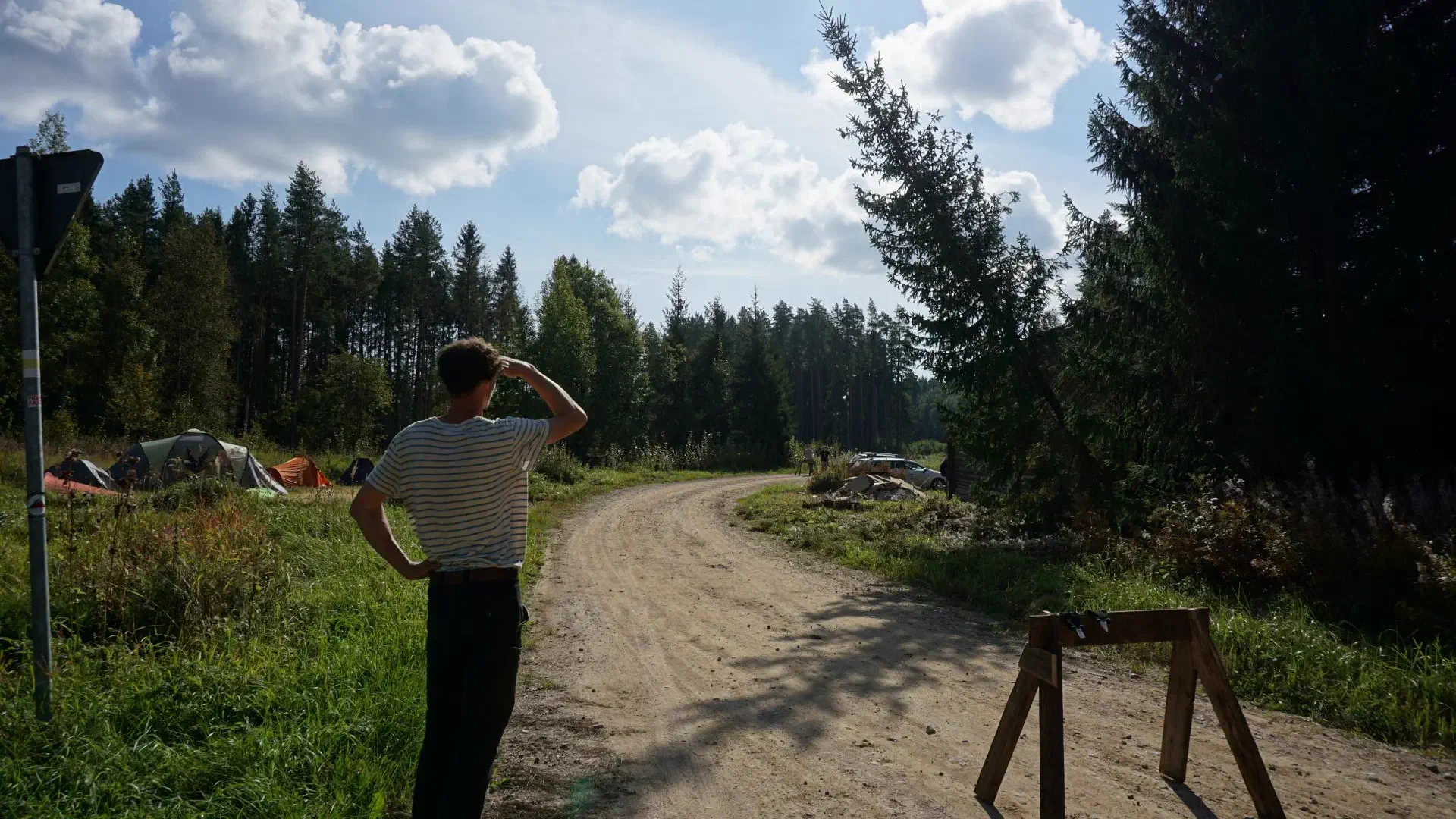 Lukas stands next to a road barrier and watches the felling work