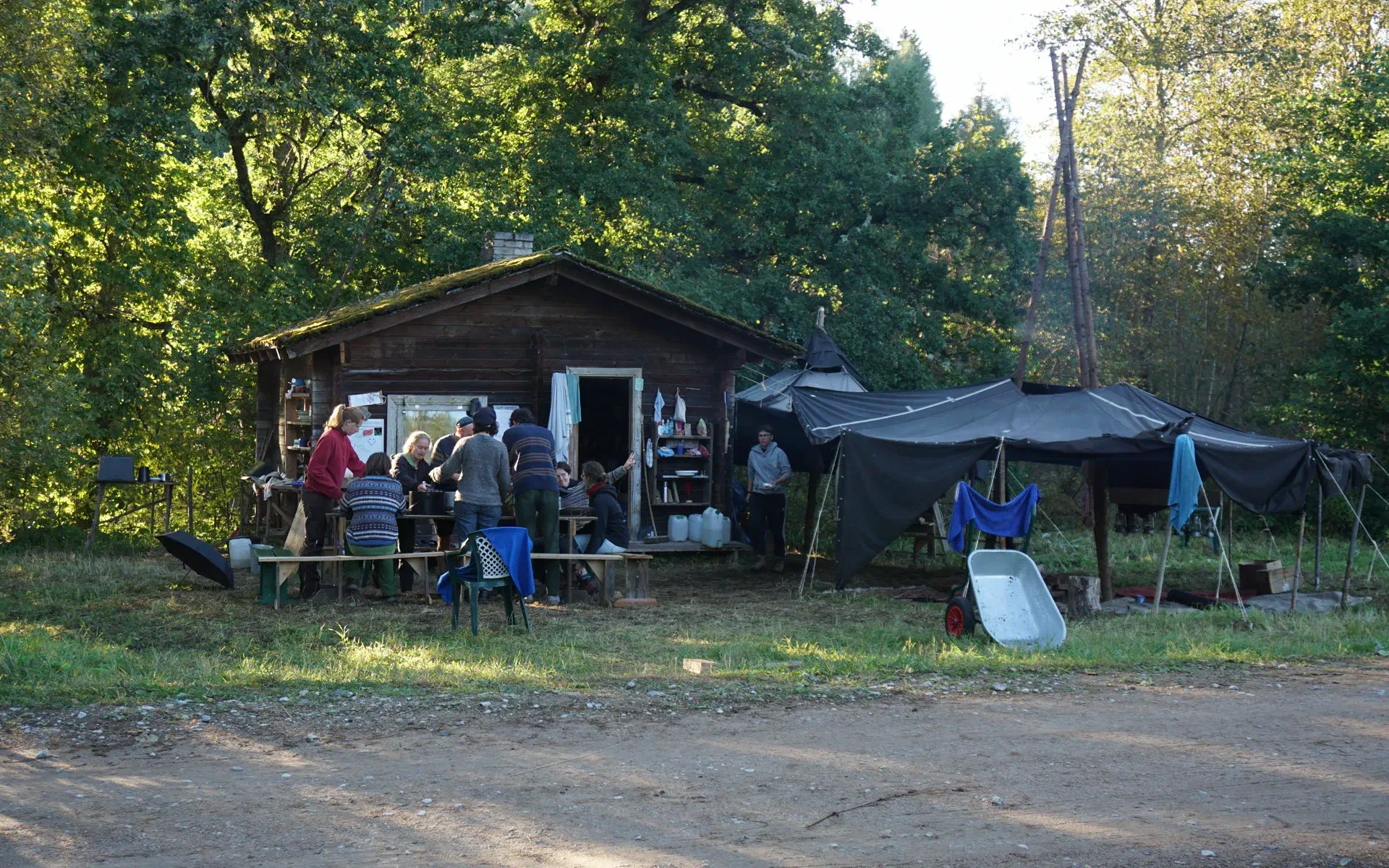 The group stands around the table and prepares dinner.