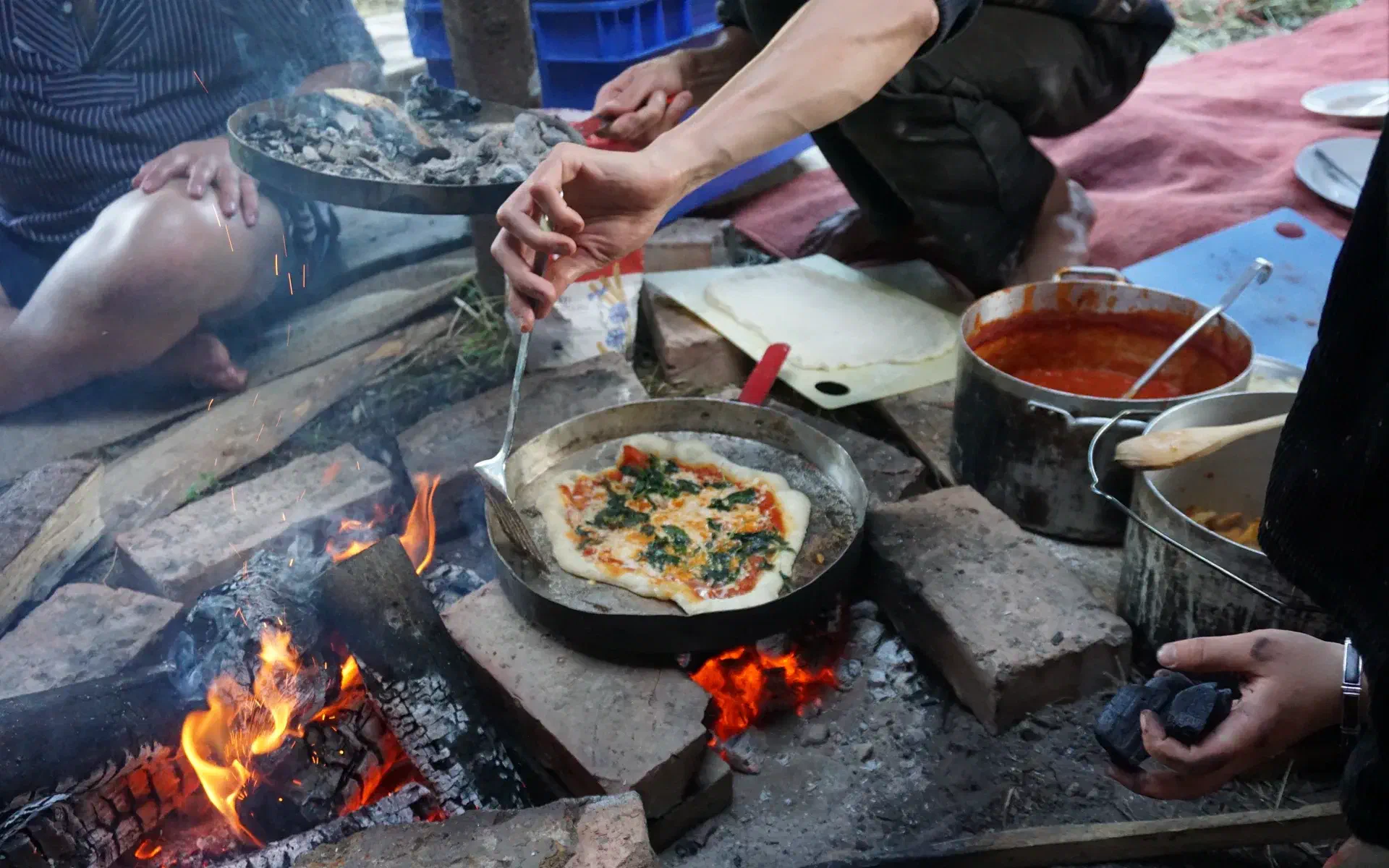 The pizza is being baked in the pot lid
