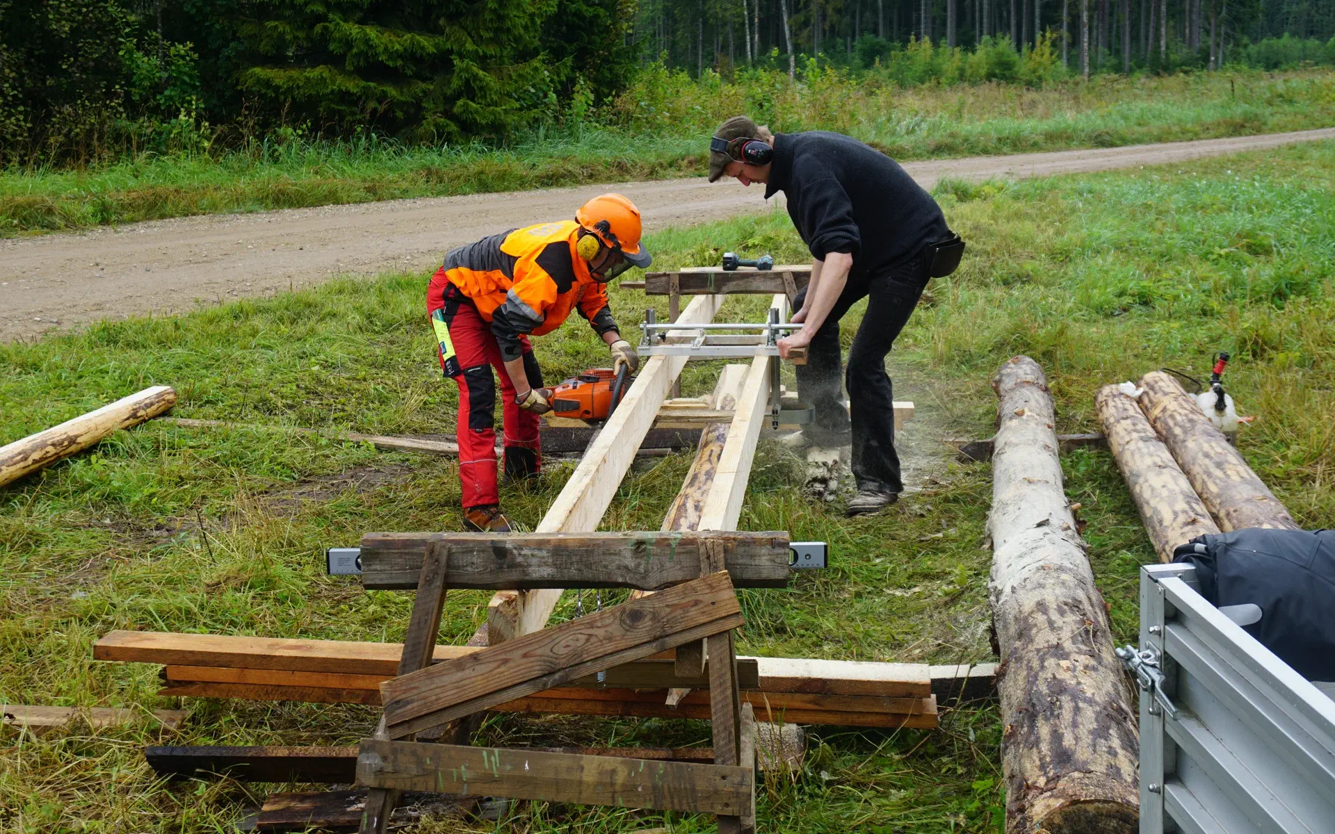 Klaas and Lola trim a beam on the mobile sawmill.