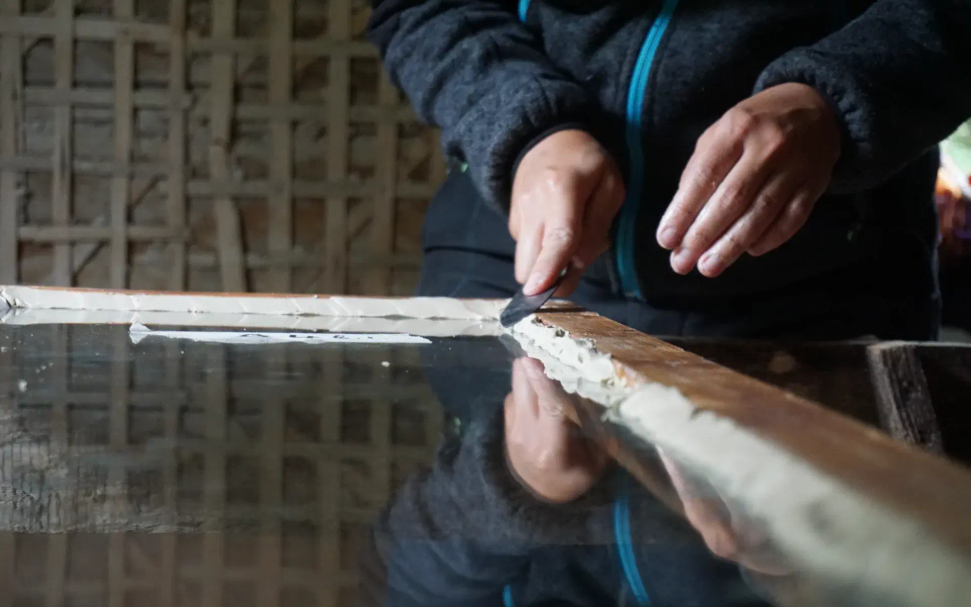 The putty is smoothed onto a window using a putty knife.