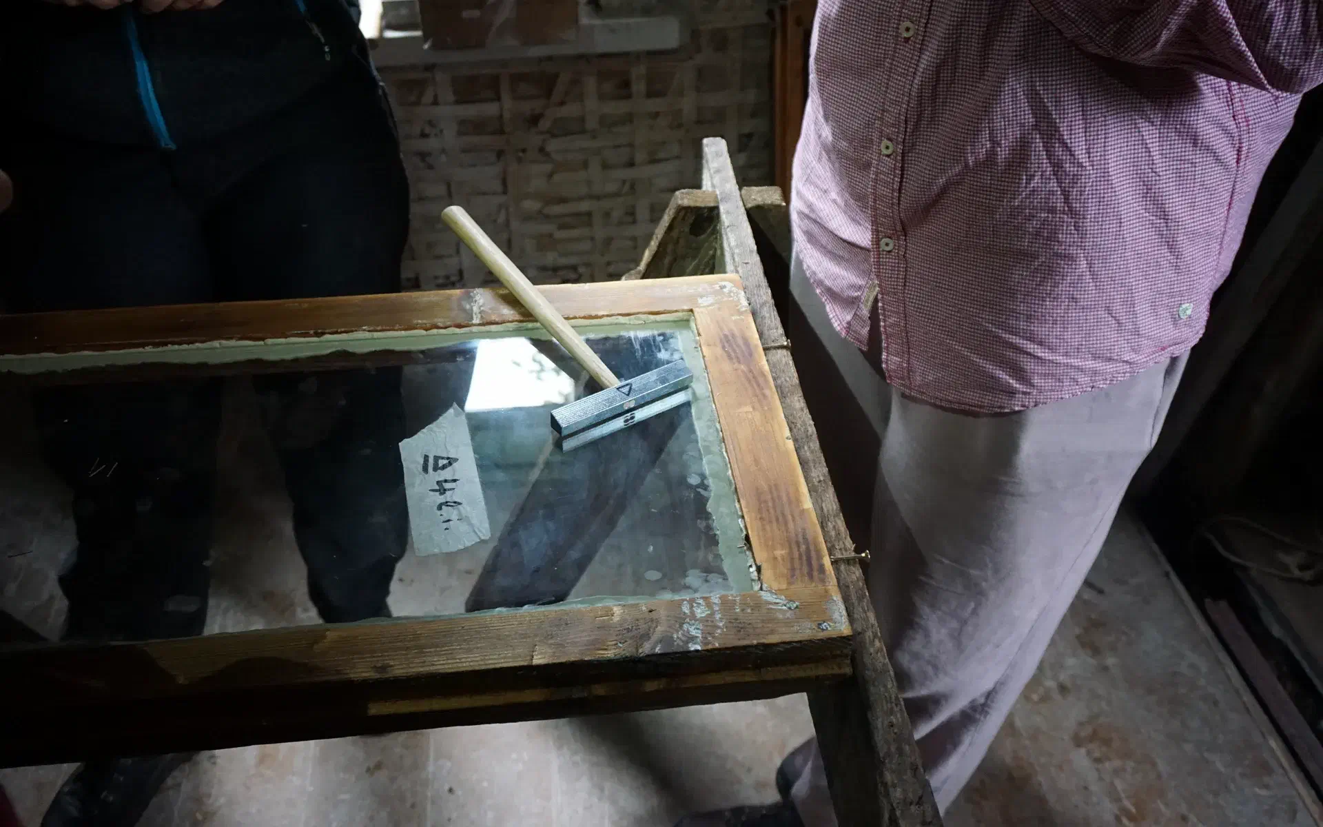 In a window frame, the pane has already been inserted into the putty bed. On top of the pane lies the glazier's hammer, which is used to drive in the glazier's nails.