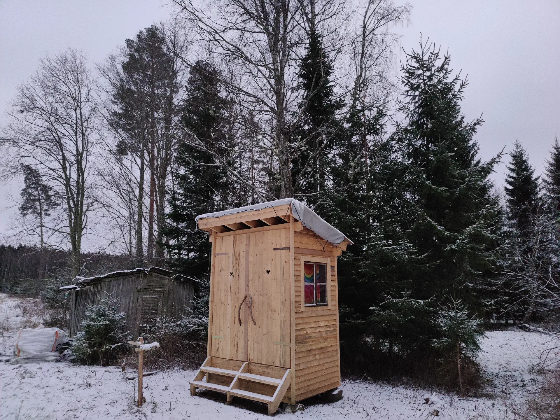 Das Klohaus ist fertig und ist von leichtem Schnee bedeckt.