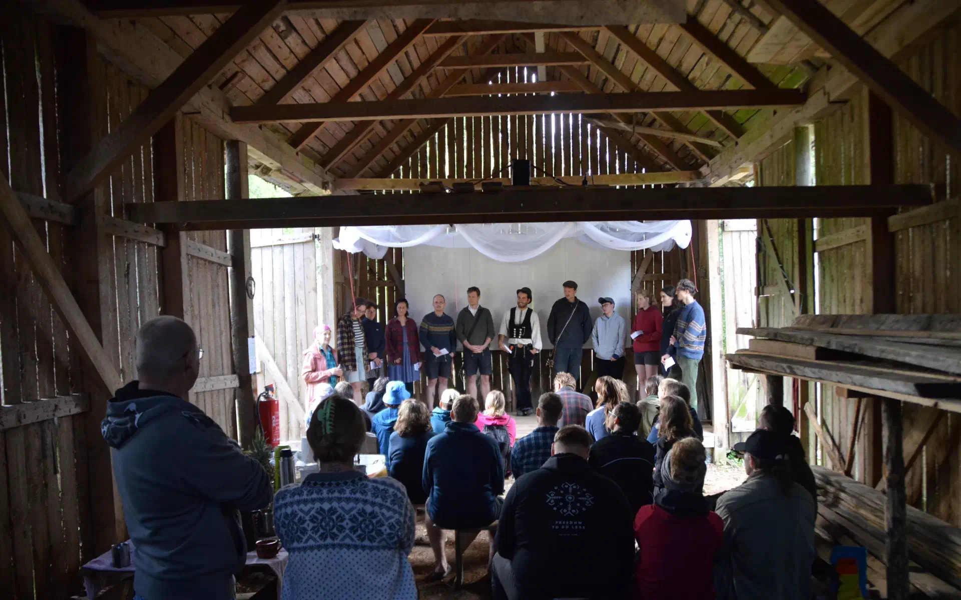 The members of the association stand on stage while Krista translates from the doorway.