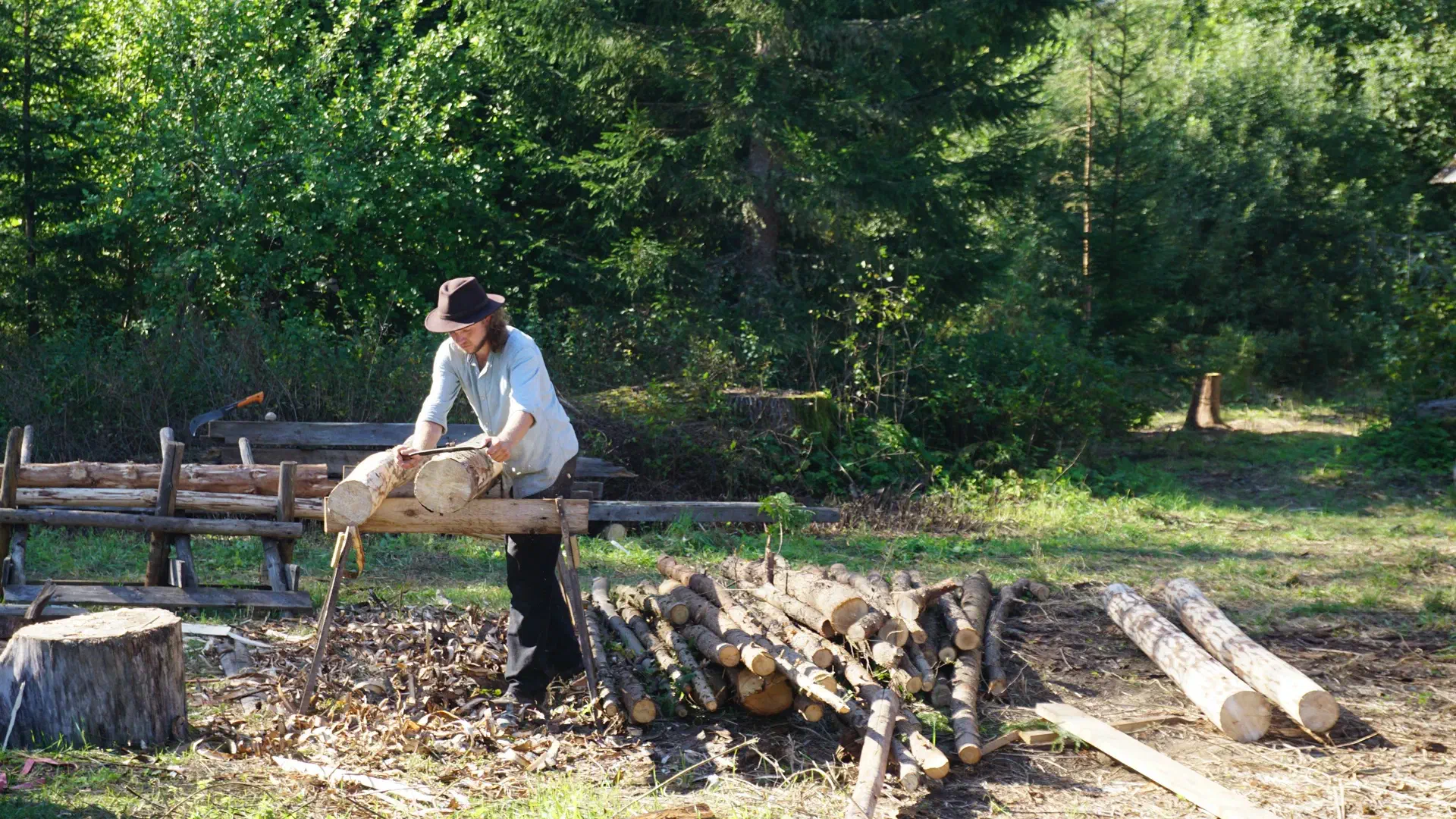 Jakob peels felled coniferous wood for future projects