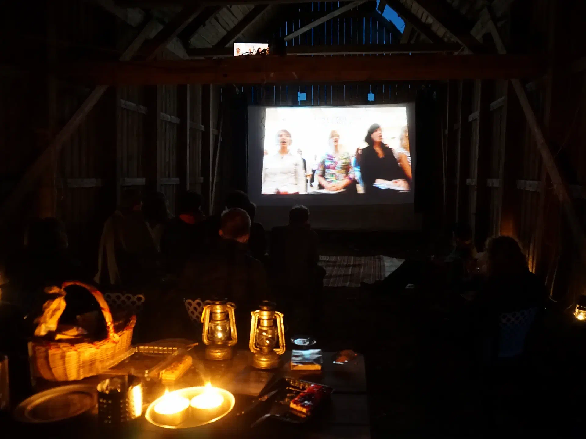 On the screen in the barn, the movie 'The singing revolution' is shown