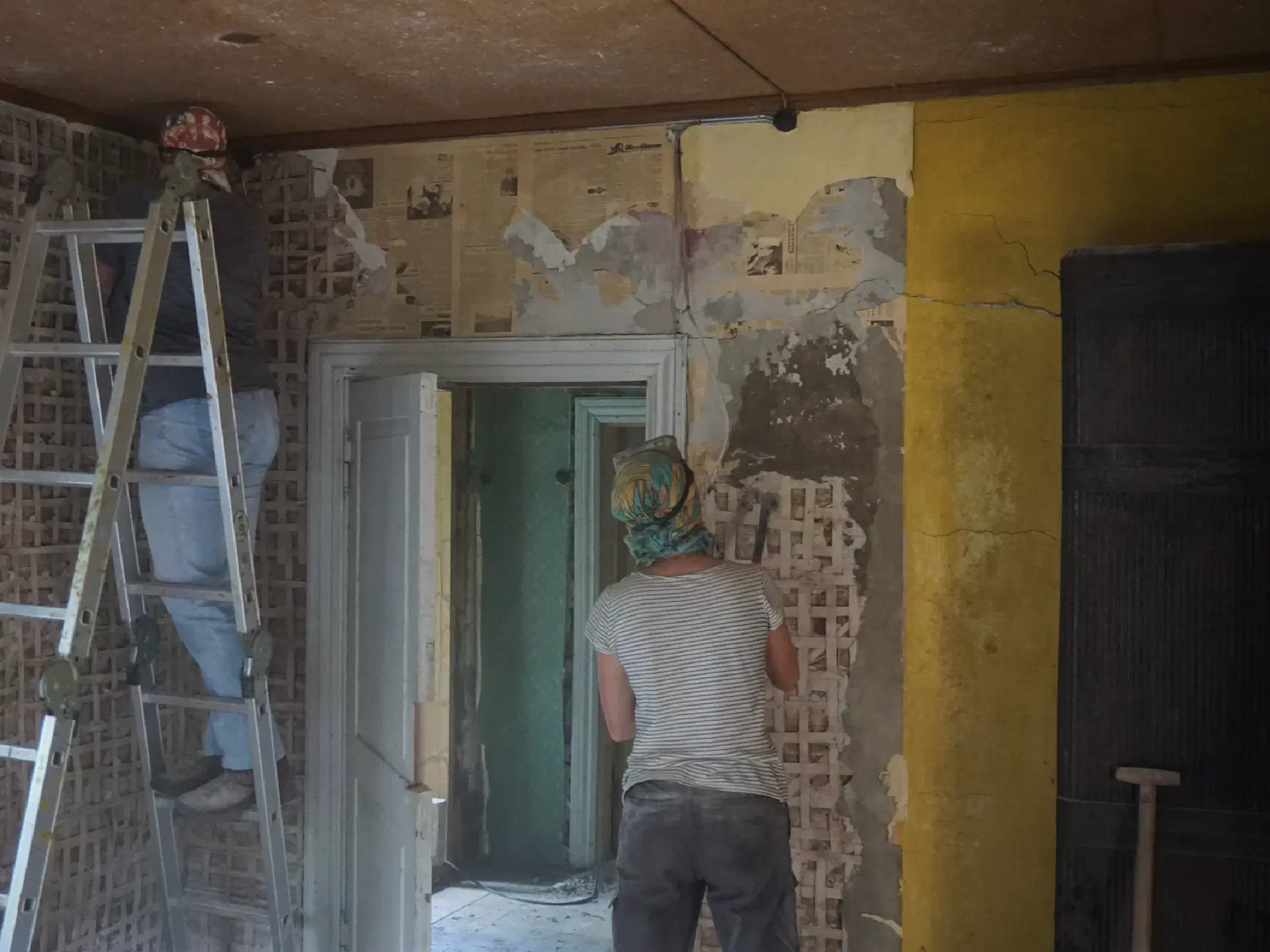 Equipped with headscarves, goggles and chisels, the plaster is knocked off