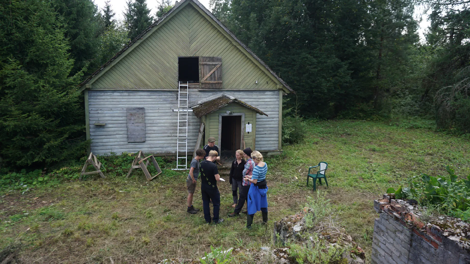 The RMK man, Krista and the association members stand in front of the main building and talk shop