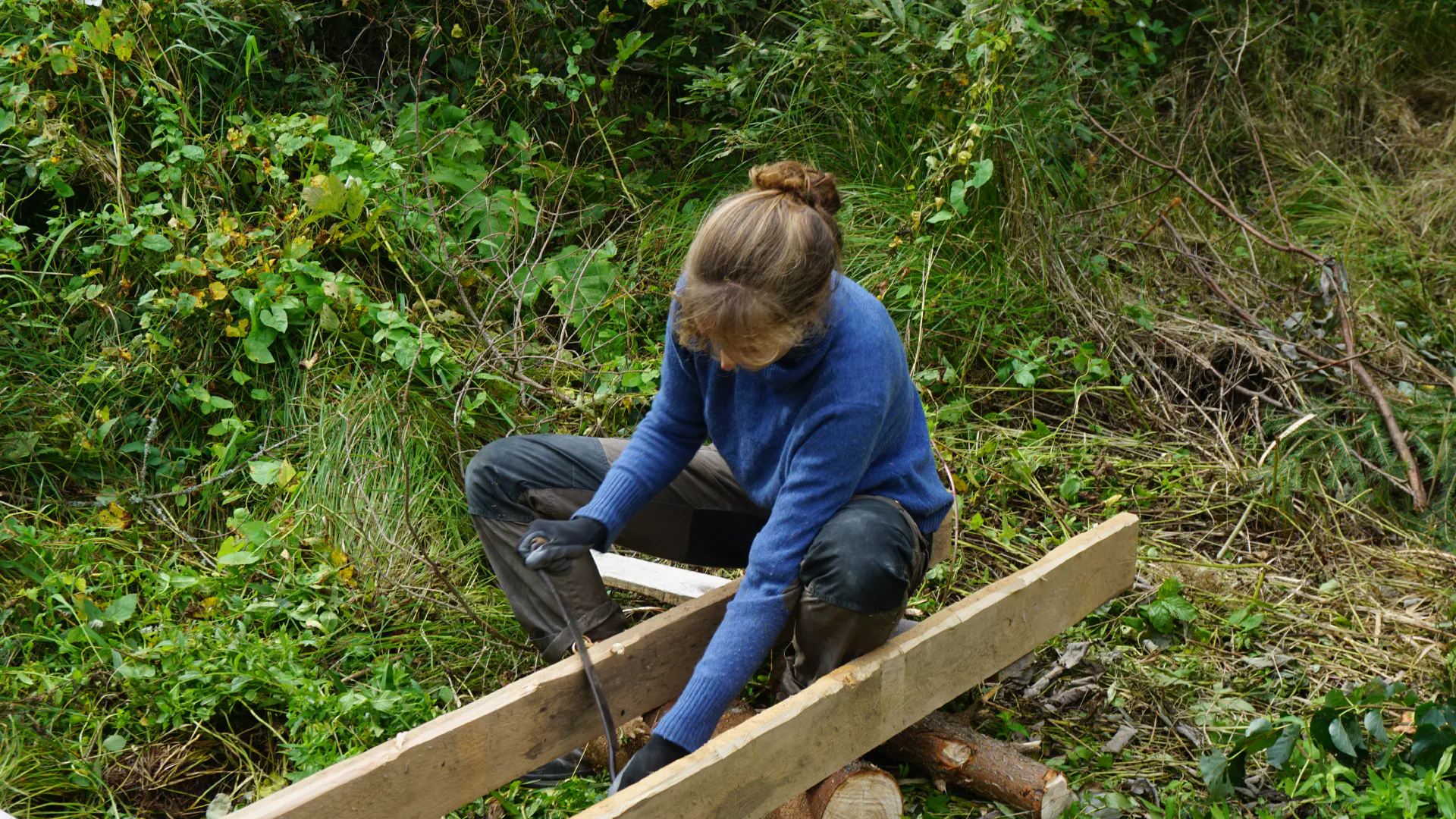 Luise chamfers the underside of the ladder with the scraper