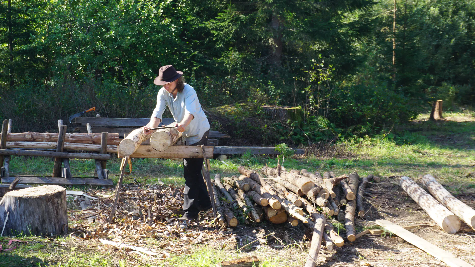 Jakob peels felled coniferous wood for future projects