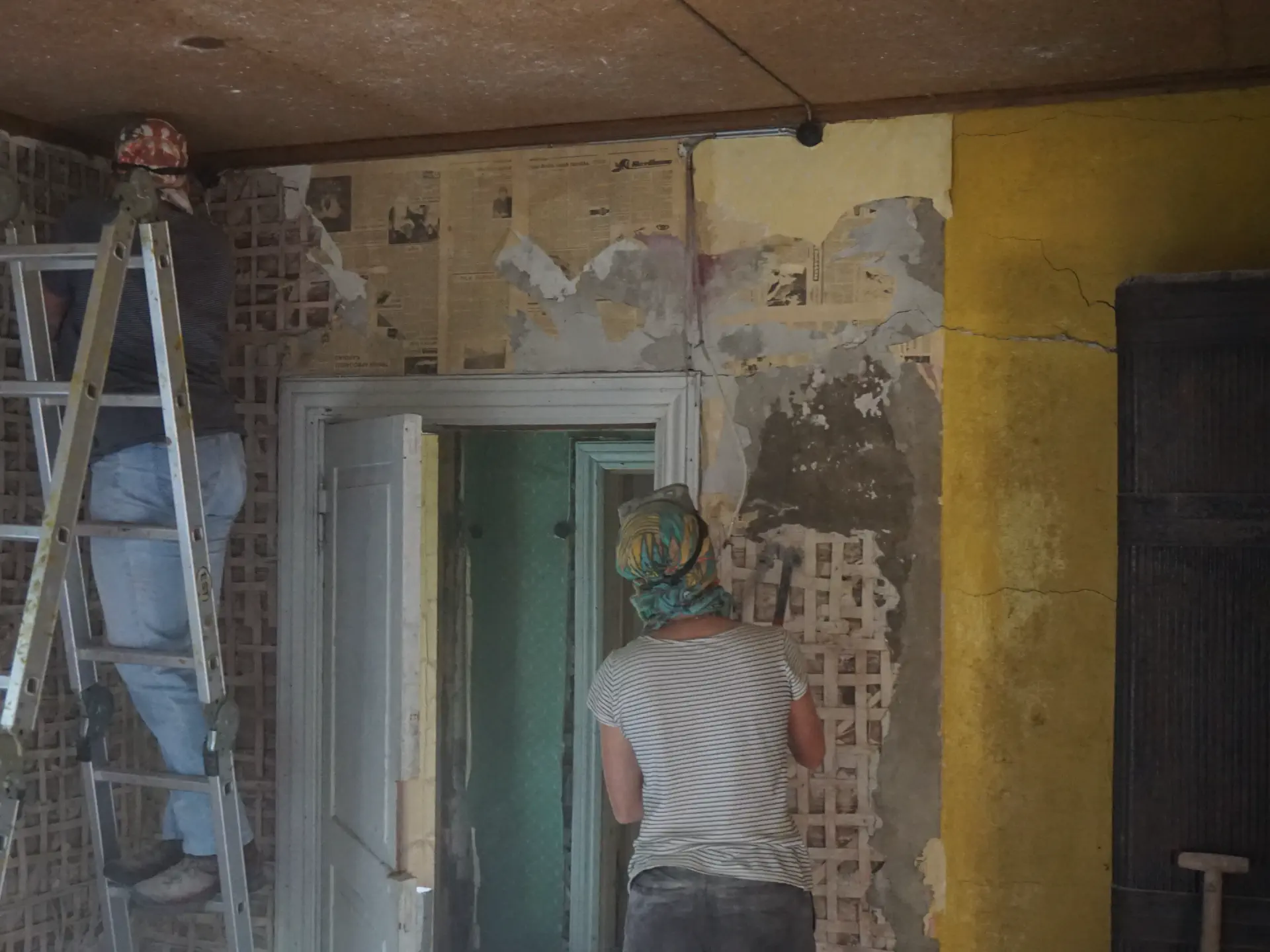 Equipped with headscarves, goggles and chisels, the plaster is knocked off